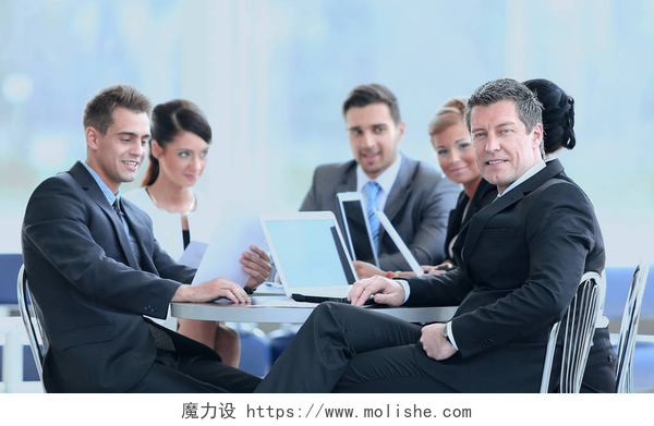 商人和他的团队坐在会议室开会商人和他的业务团队的财务文件坐在银行大厅的办公桌.